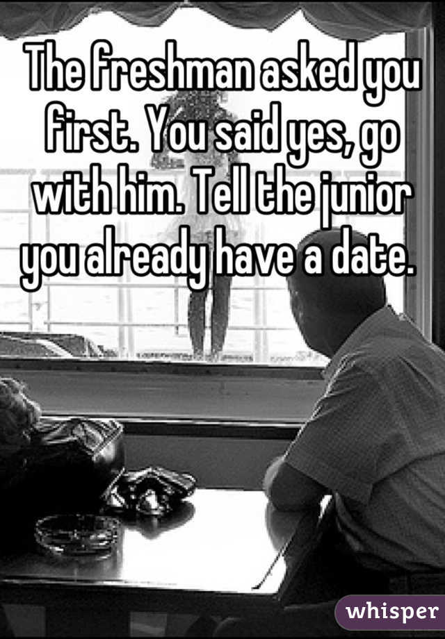 The freshman asked you first. You said yes, go with him. Tell the junior you already have a date. 