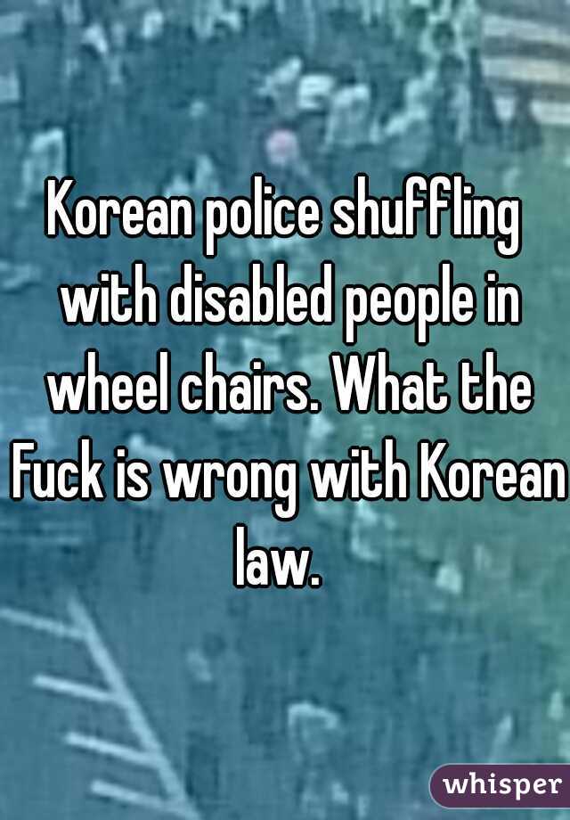 Korean police shuffling with disabled people in wheel chairs. What the Fuck is wrong with Korean law.  