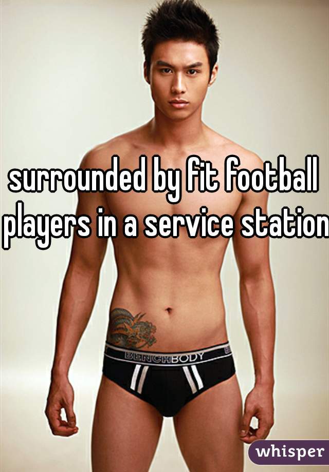 surrounded by fit football players in a service station  