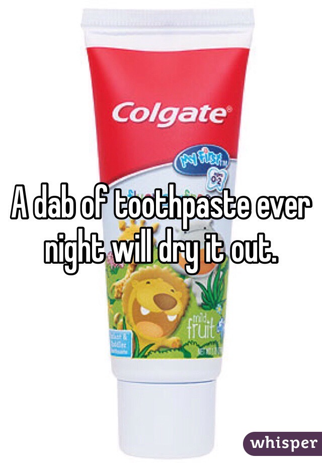 A dab of toothpaste ever night will dry it out.