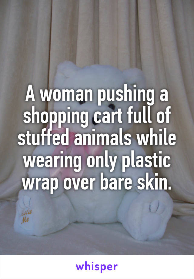 A woman pushing a shopping cart full of stuffed animals while wearing only plastic wrap over bare skin.