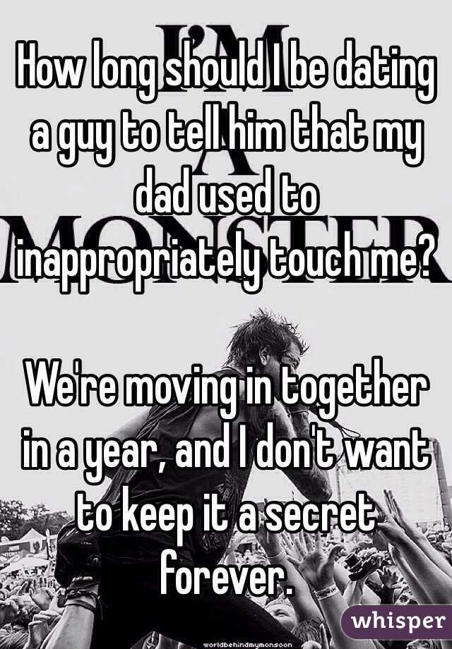 How long should I be dating a guy to tell him that my dad used to inappropriately touch me?

We're moving in together in a year, and I don't want to keep it a secret forever.