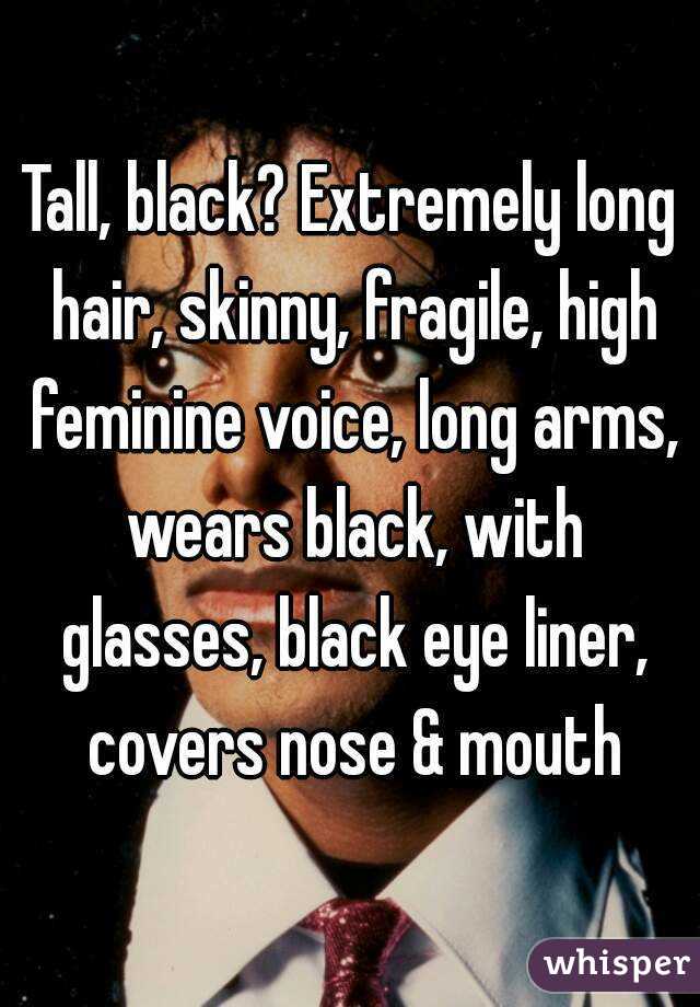 Tall, black? Extremely long hair, skinny, fragile, high feminine voice, long arms, wears black, with glasses, black eye liner, covers nose & mouth