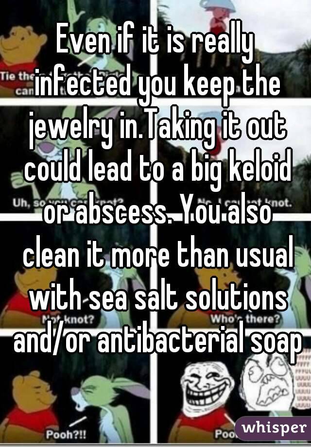 Even if it is really infected you keep the jewelry in.Taking it out could lead to a big keloid or abscess. You also clean it more than usual with sea salt solutions and/or antibacterial soap 