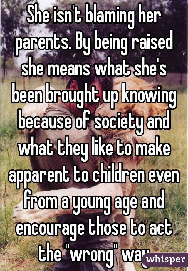 She isn't blaming her parents. By being raised she means what she's been brought up knowing because of society and what they like to make apparent to children even from a young age and encourage those to act the "wrong" way