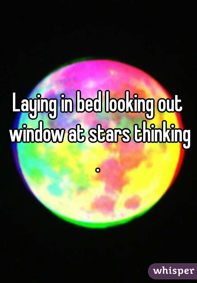 Laying in bed looking out window at stars thinking . 