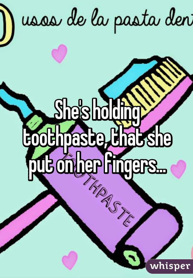 She's holding toothpaste, that she put on her fingers...