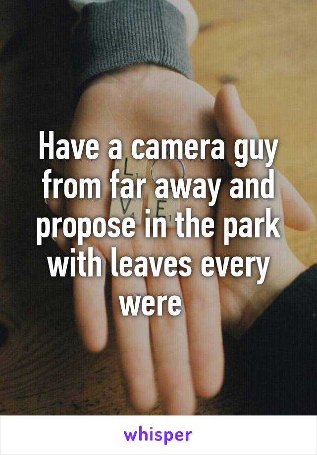 Have a camera guy from far away and propose in the park with leaves every were  