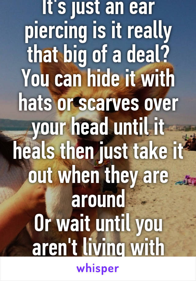 It's just an ear piercing is it really that big of a deal?
You can hide it with hats or scarves over your head until it heals then just take it out when they are around
Or wait until you aren't living with them 