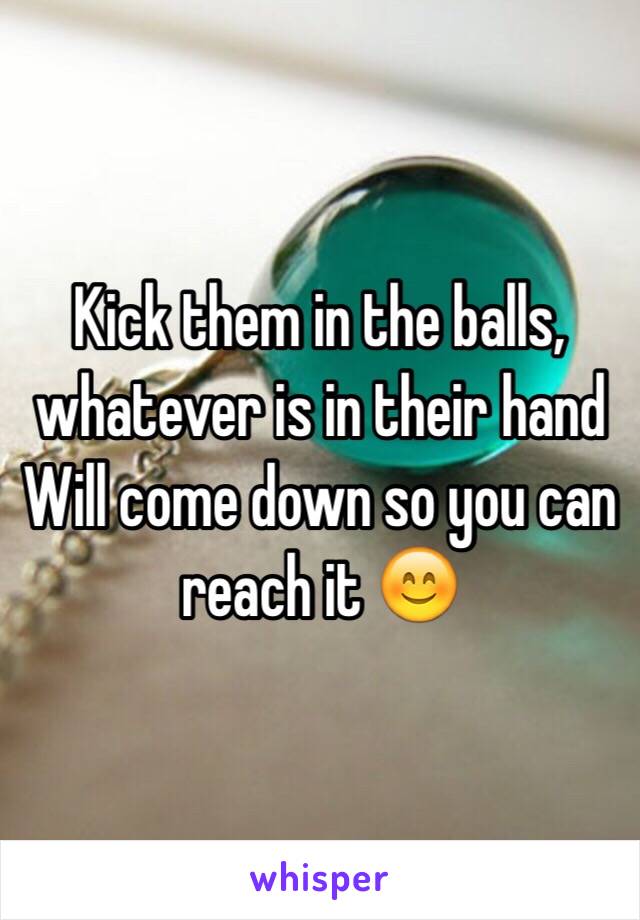 Kick them in the balls, whatever is in their hand Will come down so you can reach it 😊