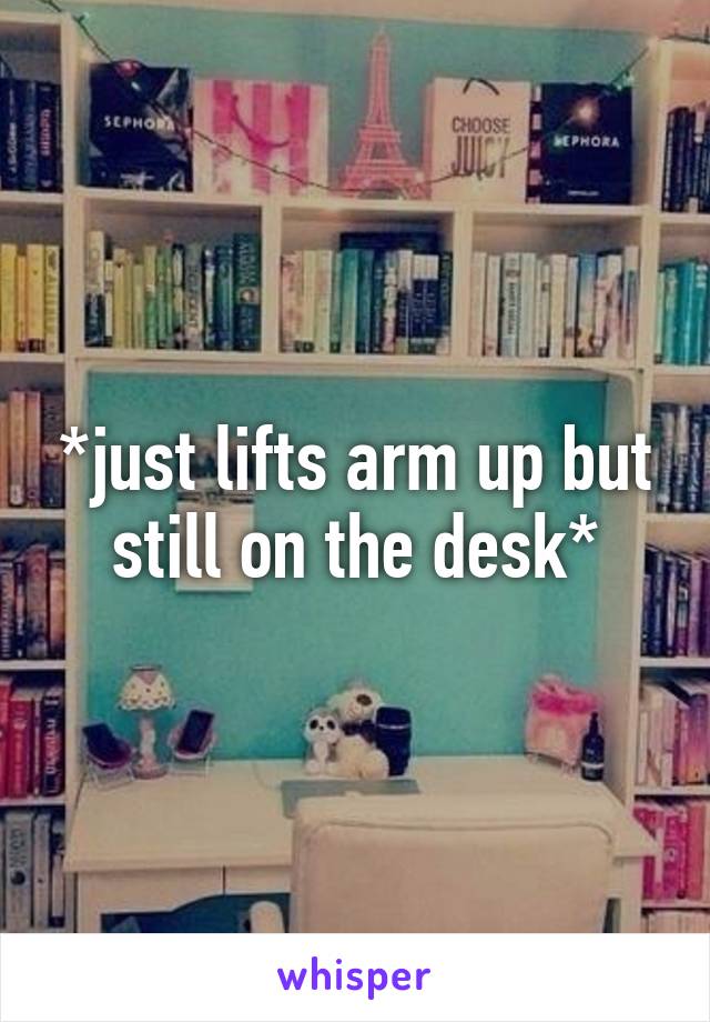 *just lifts arm up but still on the desk*