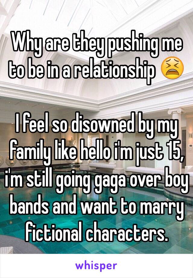 Why are they pushing me to be in a relationship 😫

I feel so disowned by my family like hello i'm just 15, i'm still going gaga over boy bands and want to marry fictional characters.
