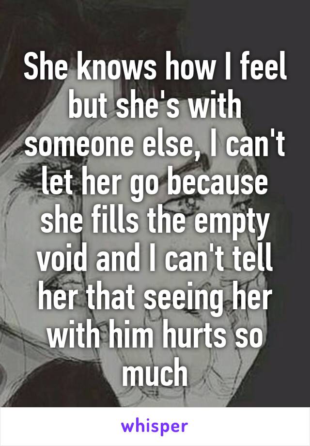 She knows how I feel but she's with someone else, I can't let her go because she fills the empty void and I can't tell her that seeing her with him hurts so much