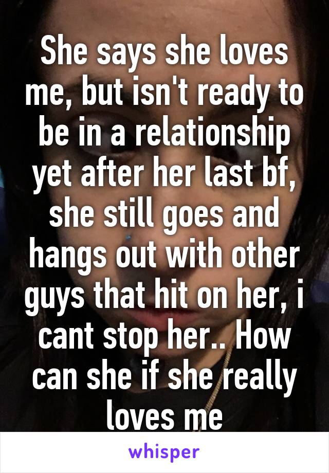 She says she loves me, but isn't ready to be in a relationship yet after her last bf, she still goes and hangs out with other guys that hit on her, i cant stop her.. How can she if she really loves me