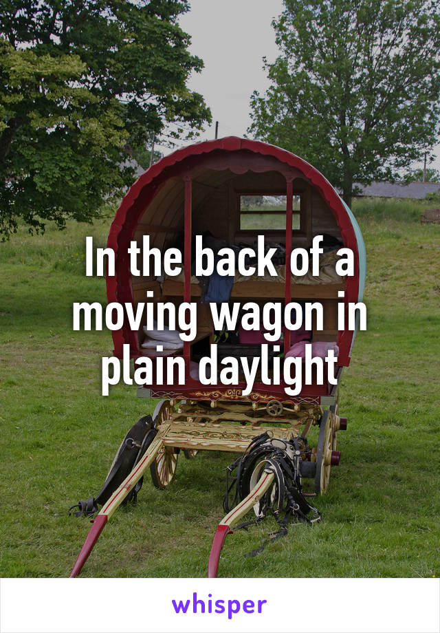 In the back of a moving wagon in plain daylight