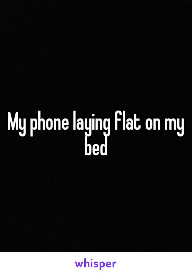 My phone laying flat on my bed 