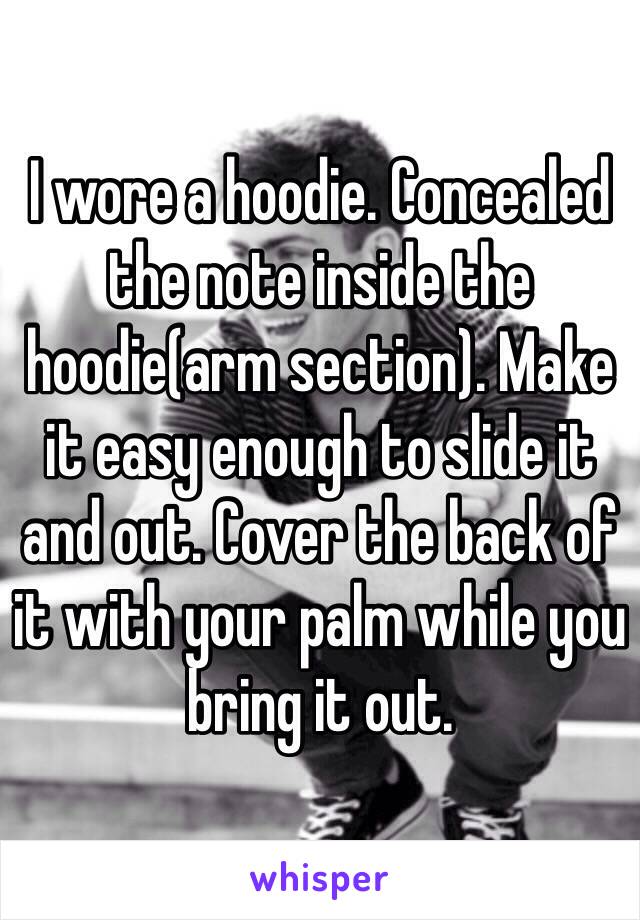 I wore a hoodie. Concealed the note inside the hoodie(arm section). Make it easy enough to slide it and out. Cover the back of it with your palm while you bring it out. 