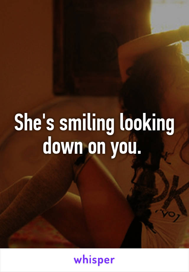 She's smiling looking down on you. 