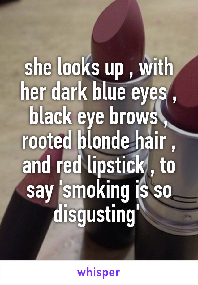 she looks up , with her dark blue eyes , black eye brows , rooted blonde hair , and red lipstick , to say 'smoking is so disgusting' 