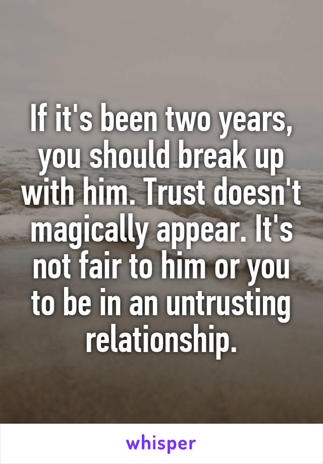 If it's been two years, you should break up with him. Trust doesn't magically appear. It's not fair to him or you to be in an untrusting relationship.