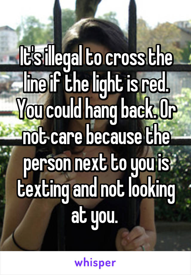 It's illegal to cross the line if the light is red. You could hang back. Or not care because the person next to you is texting and not looking at you. 