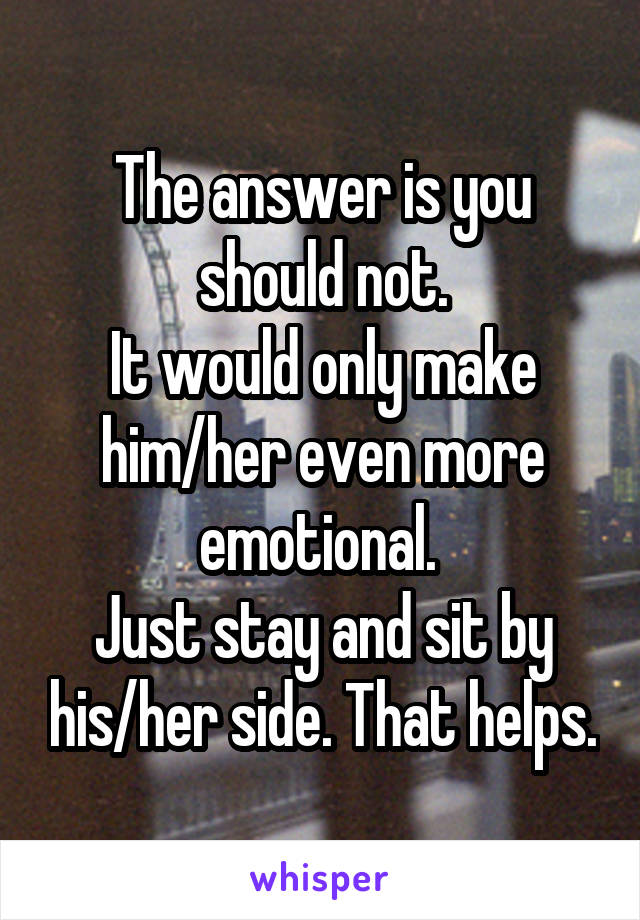 The answer is you should not.
It would only make him/her even more emotional. 
Just stay and sit by his/her side. That helps.