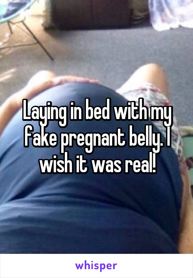 Laying in bed with my fake pregnant belly. I wish it was real!