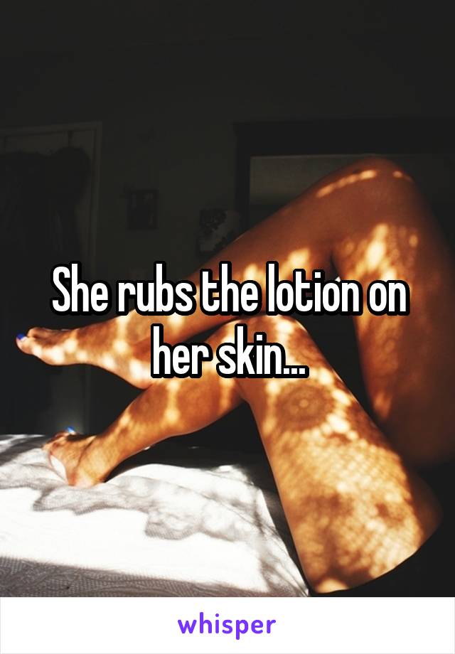 She rubs the lotion on her skin...