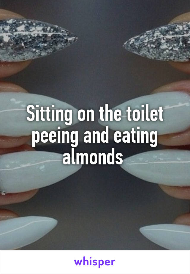 Sitting on the toilet peeing and eating almonds 