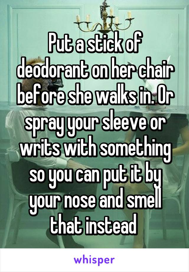 Put a stick of deodorant on her chair before she walks in. Or spray your sleeve or writs with something so you can put it by your nose and smell that instead 