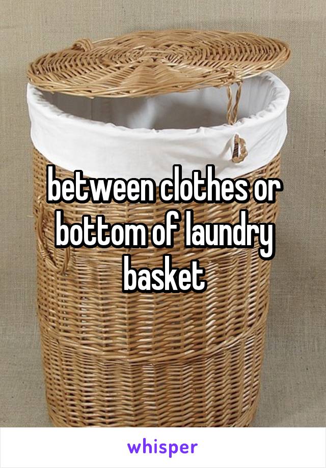 between clothes or bottom of laundry basket