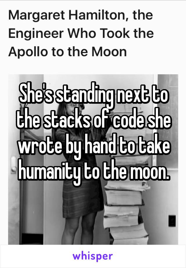 She's standing next to the stacks of code she wrote by hand to take humanity to the moon.