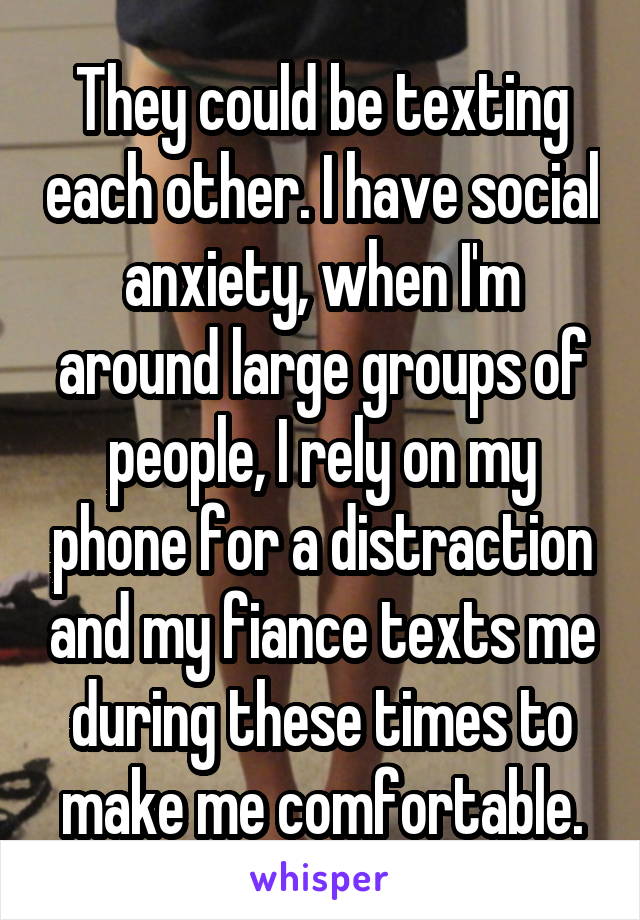 They could be texting each other. I have social anxiety, when I'm around large groups of people, I rely on my phone for a distraction and my fiance texts me during these times to make me comfortable.