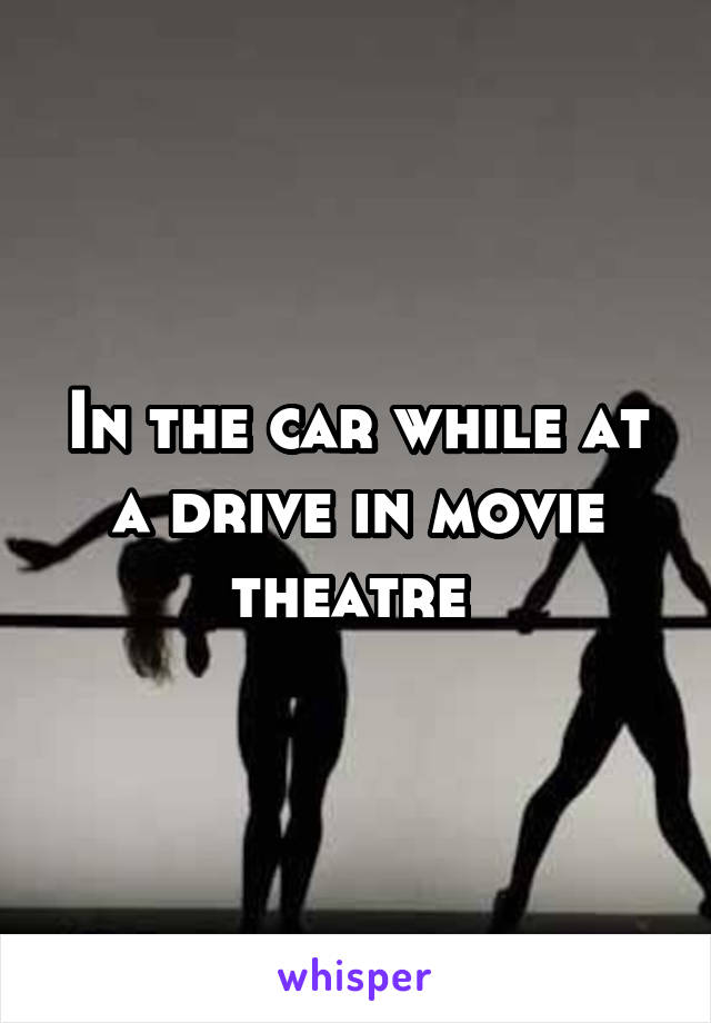 In the car while at a drive in movie theatre 