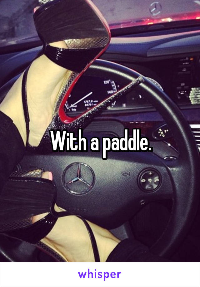 With a paddle.