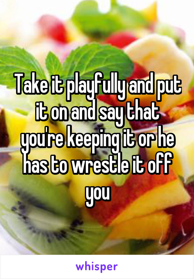 Take it playfully and put it on and say that you're keeping it or he has to wrestle it off you