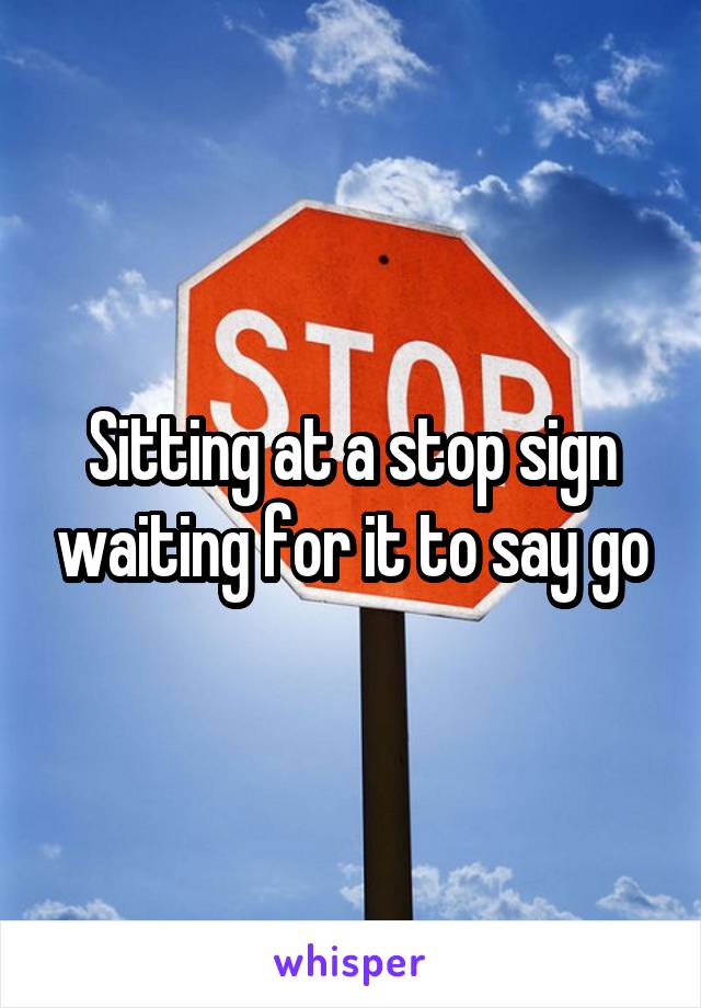 Sitting at a stop sign waiting for it to say go