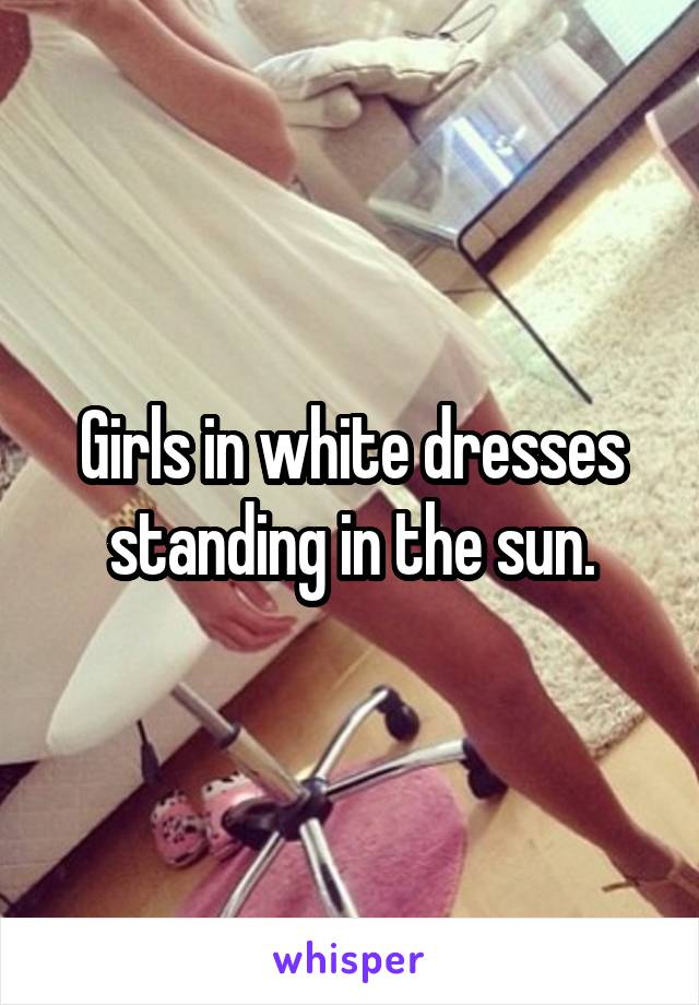 Girls in white dresses standing in the sun.