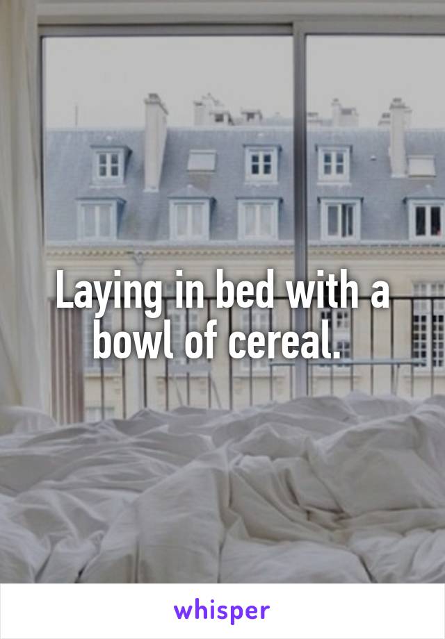 Laying in bed with a bowl of cereal. 