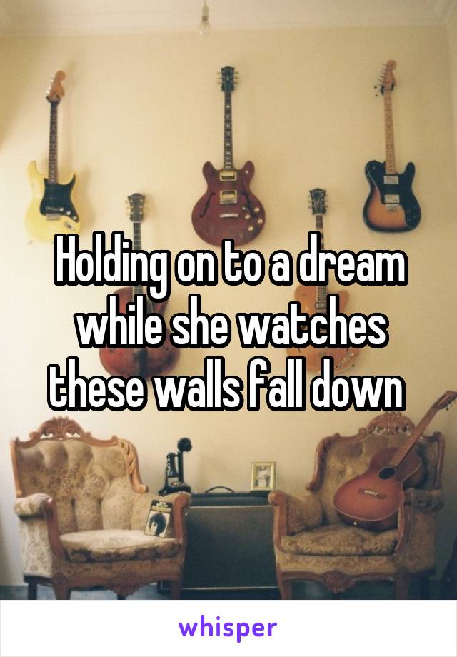 Holding on to a dream while she watches these walls fall down 