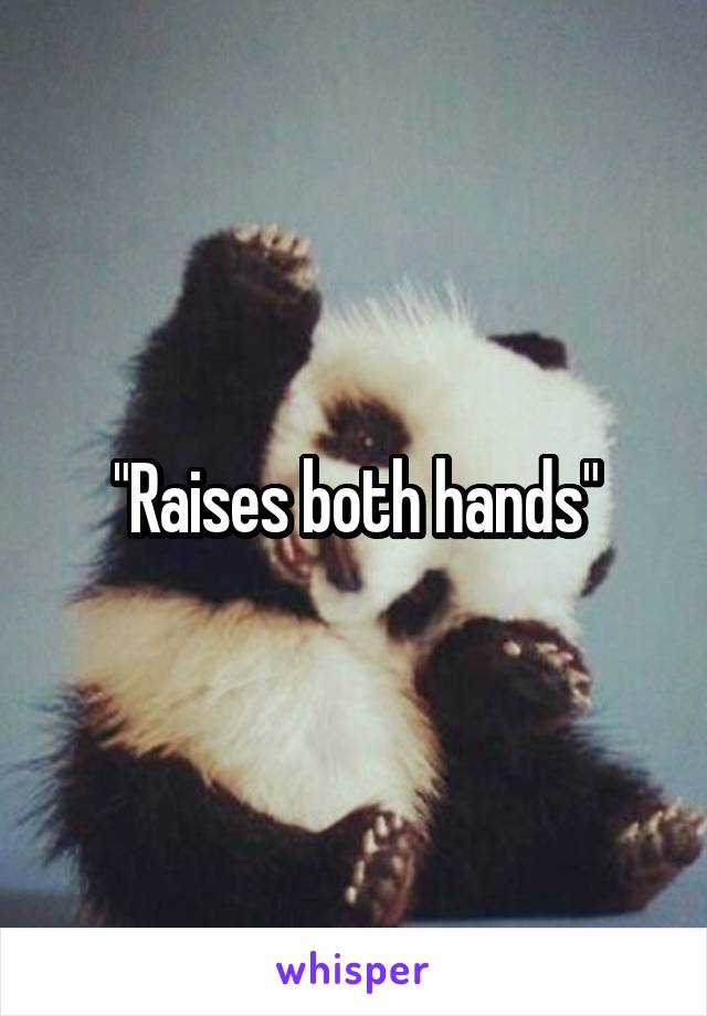 "Raises both hands"