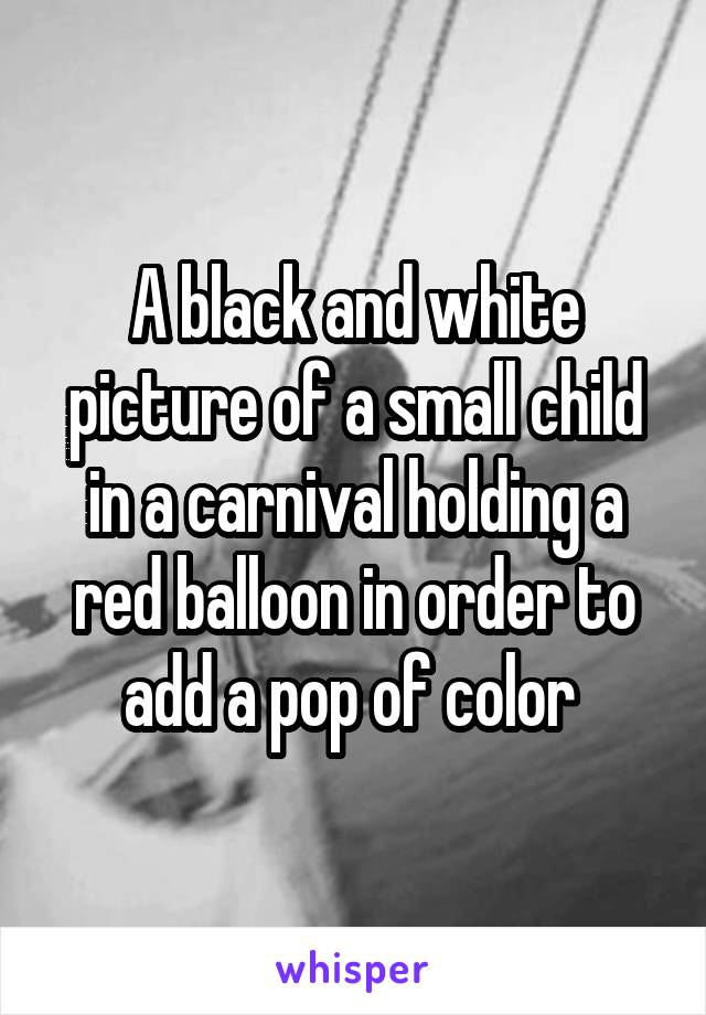 A black and white picture of a small child in a carnival holding a red balloon in order to add a pop of color 