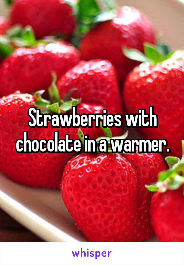 Strawberries with chocolate in a warmer.