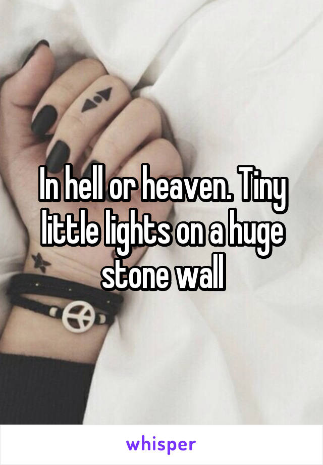 In hell or heaven. Tiny little lights on a huge stone wall