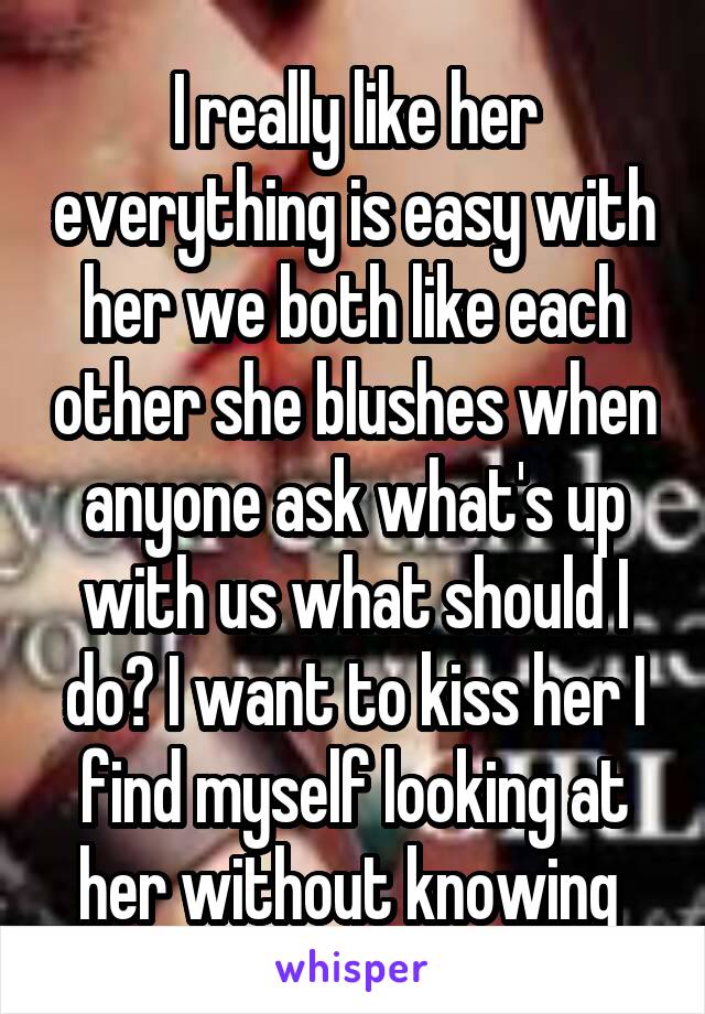I really like her everything is easy with her we both like each other she blushes when anyone ask what's up with us what should I do? I want to kiss her I find myself looking at her without knowing 