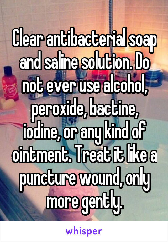 Clear antibacterial soap and saline solution. Do not ever use alcohol, peroxide, bactine, iodine, or any kind of ointment. Treat it like a puncture wound, only more gently.