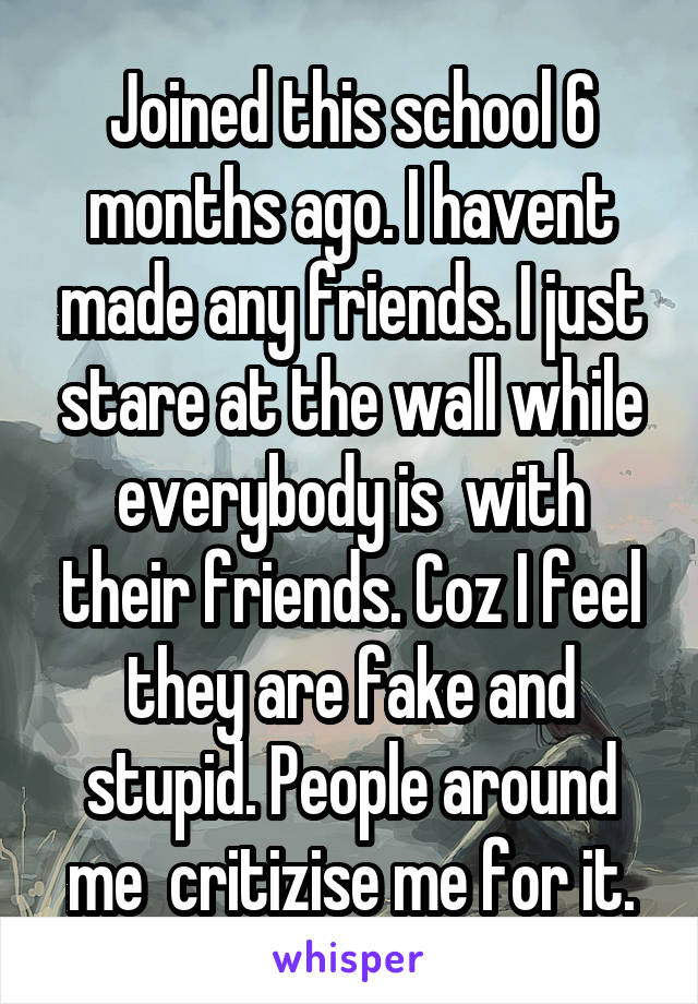 Joined this school 6 months ago. I havent made any friends. I just stare at the wall while everybody is  with their friends. Coz I feel they are fake and stupid. People around me  critizise me for it.