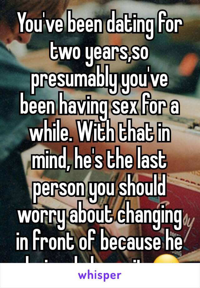 You've been dating for two years,so presumably you've been having sex for a while. With that in mind, he's the last person you should worry about changing in front of because he obviously loves it ☺