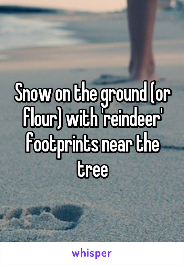 Snow on the ground (or flour) with 'reindeer' footprints near the tree