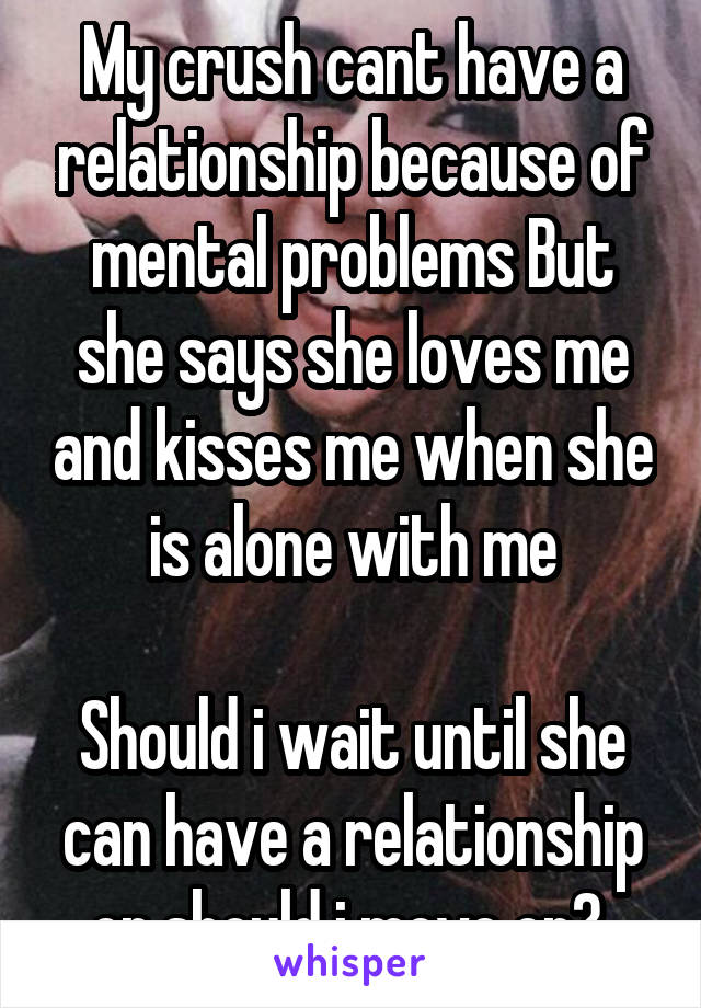 My crush cant have a relationship because of mental problems But she says she loves me and kisses me when she is alone with me

Should i wait until she can have a relationship or should i move on? 